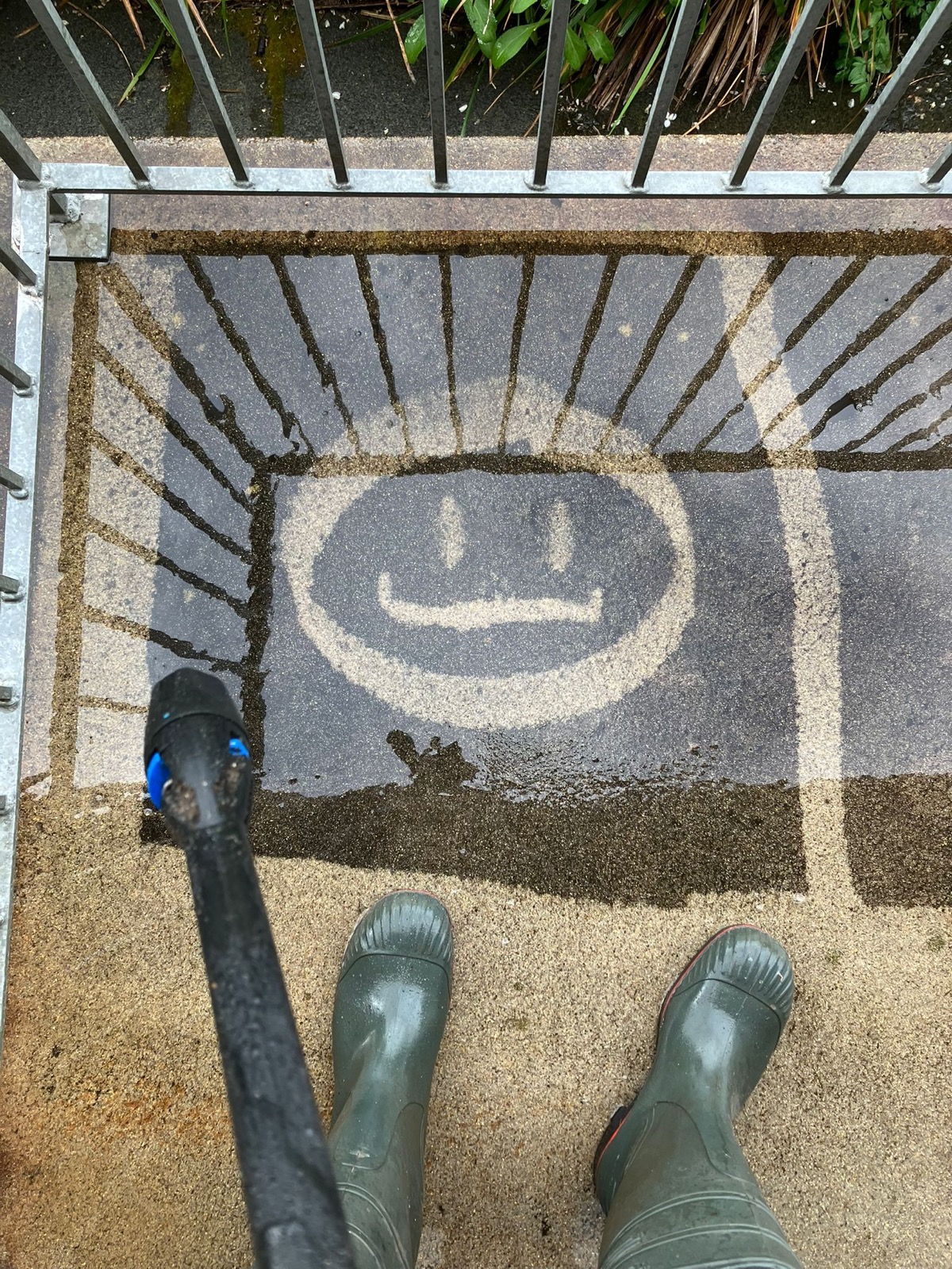 A smiley face cleaned into decking